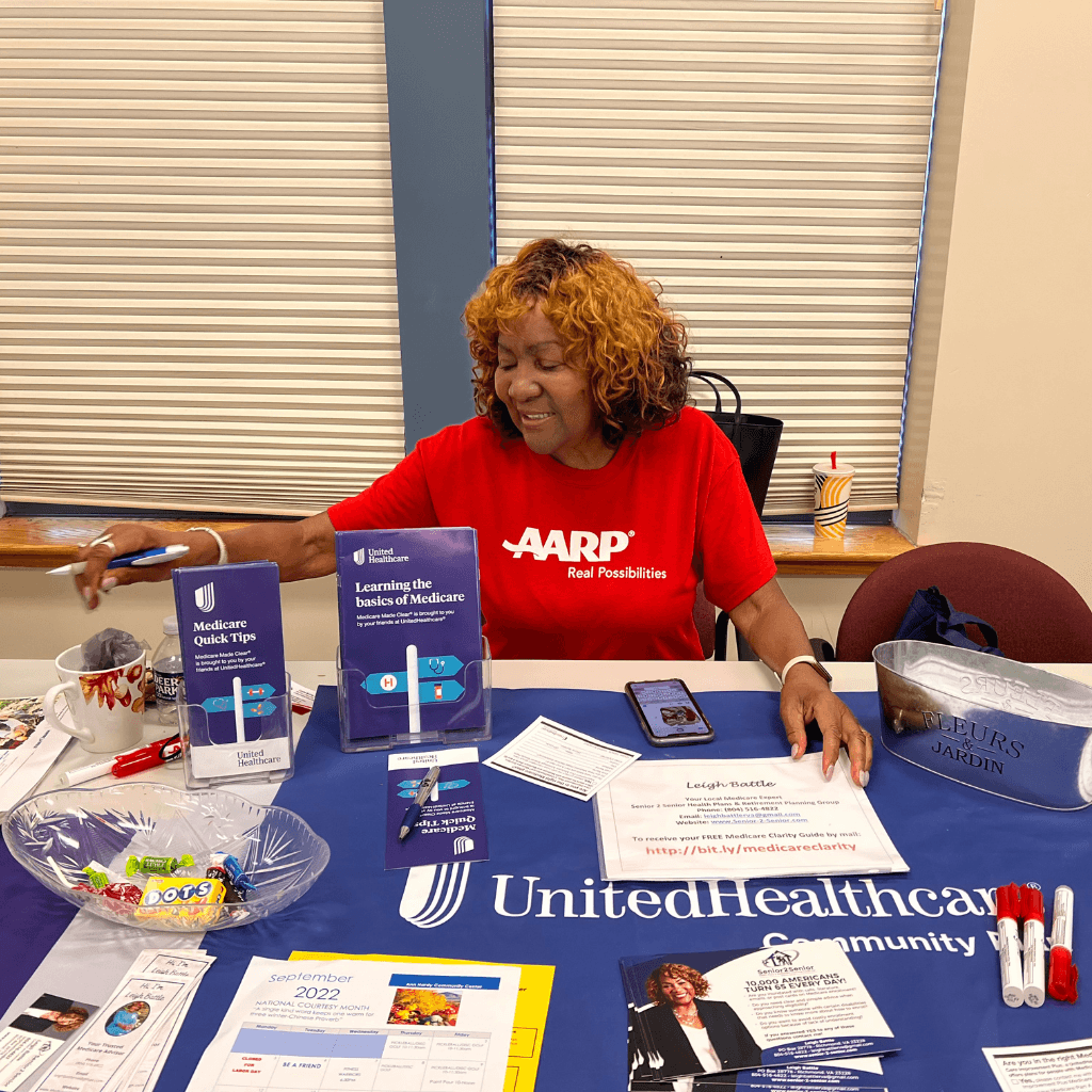 Leigh sitting at event booth to share Medicare information