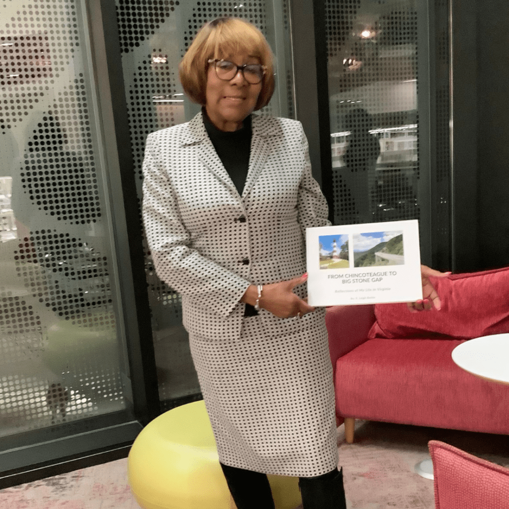 Photo of Leigh Battle holding a hardcover copy of the book she wrote in 2023, "From Chincoteague to Big Stone Gap"